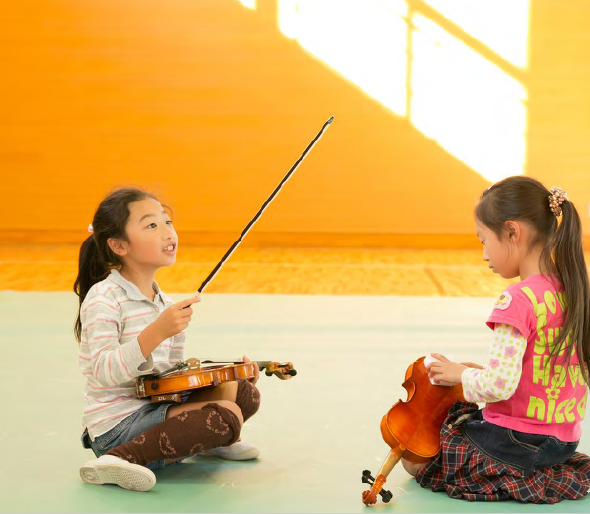 zwei musizierende Mädchen von El Sistema in Asien